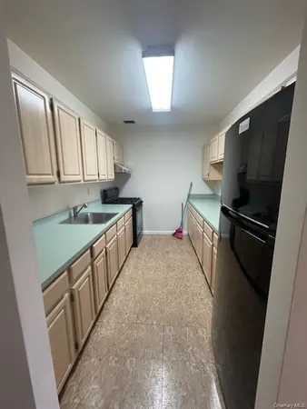 a kitchen with a sink a refrigerator and cabinets