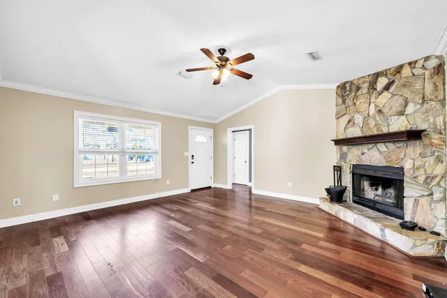 a view of an empty room with window and fireplace