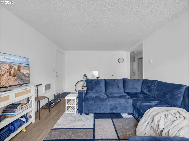 a living room with furniture a flat screen tv and a window