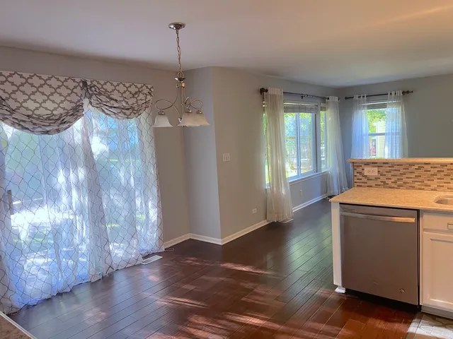 a kitchen with granite countertop white cabinets and wooden floor