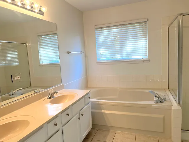a bathroom with a granite countertop sink and a bathtub