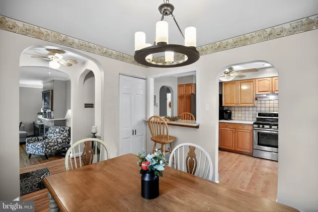 a kitchen with a stove a sink and a dining table with wooden floor