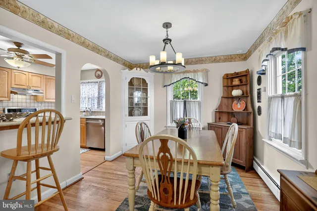 a view of a dining room with furniture a chandelier and wooden floor
