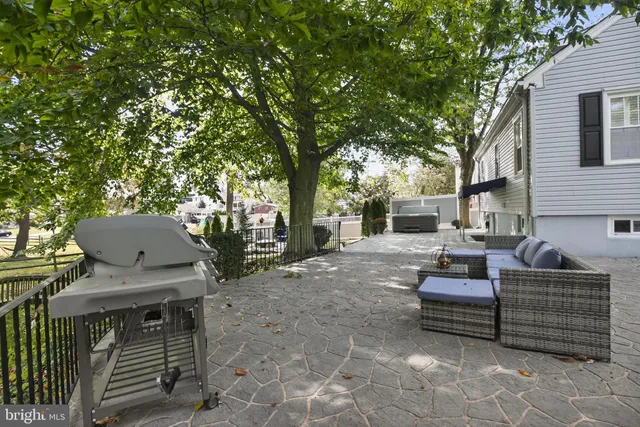 a view of a patio with table and chairs and a barbeque