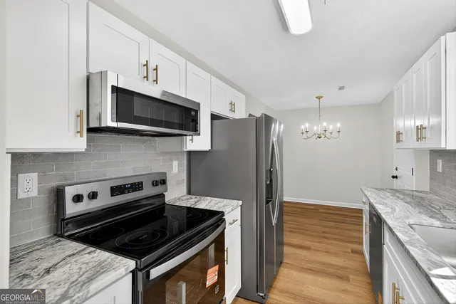 a kitchen with stainless steel appliances granite countertop a stove a refrigerator and a microwave