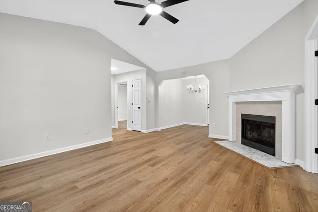 a view of empty room with wooden floor and fireplace