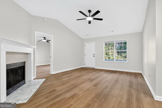an empty room with windows and fireplace