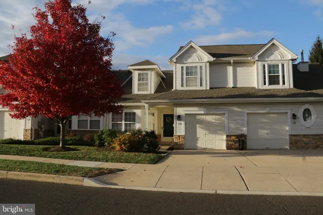 a front view of a house with a yard and trees