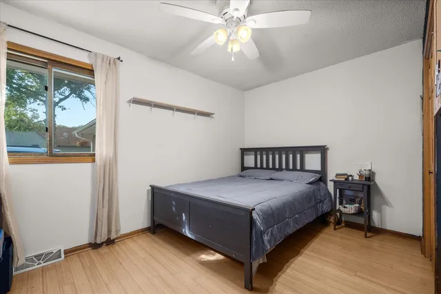 a spacious bedroom with a bed and a dresser