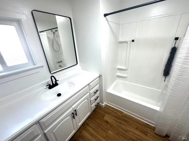 a bathroom with a tub sink and mirror