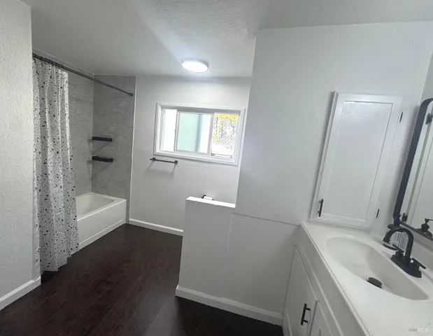 a bathroom with a sink a bathtub and a mirror
