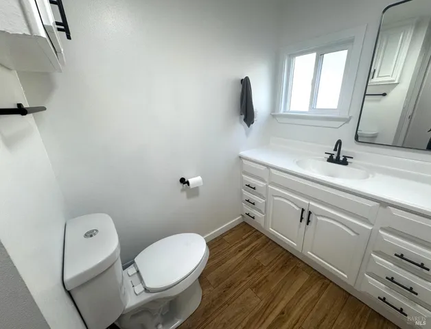 a bathroom with a granite countertop toilet sink and mirror