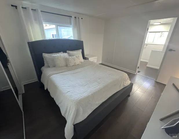 a large bed sitting in a bedroom next to a window
