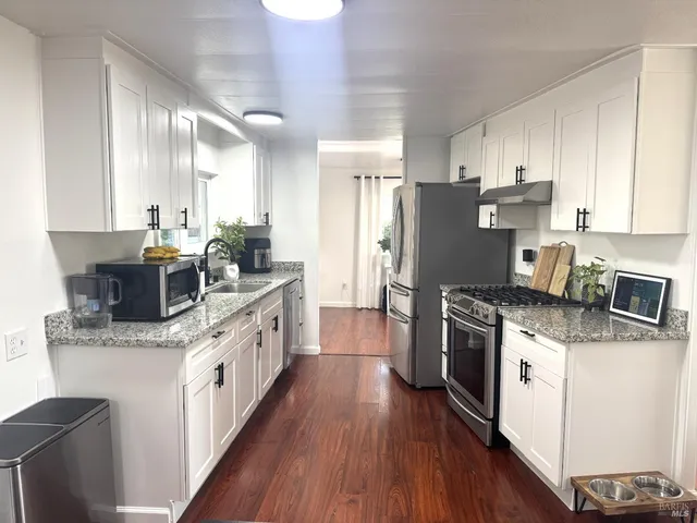 a kitchen with stainless steel appliances granite countertop a stove a sink dishwasher and a refrigerator