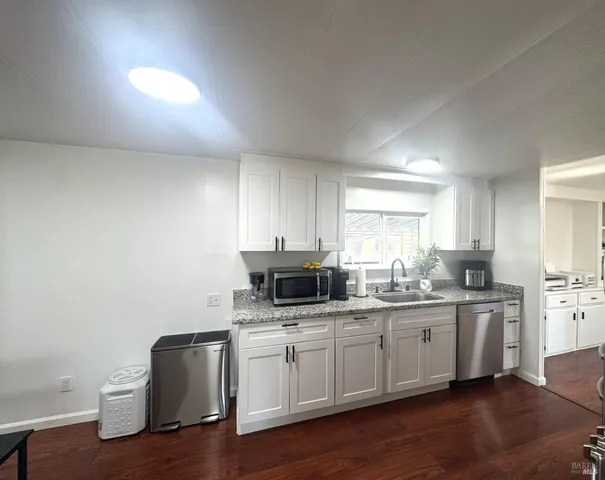 a kitchen with sink cabinets and wooden floor