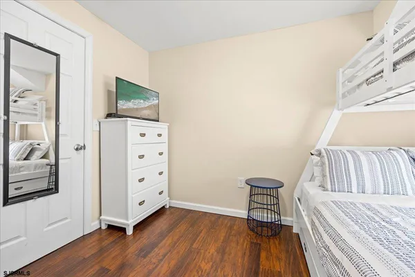 a view of a bedroom with furniture and wooden floor