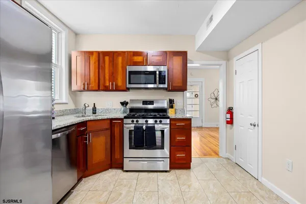 a kitchen with stainless steel appliances granite countertop a stove a sink and a microwave