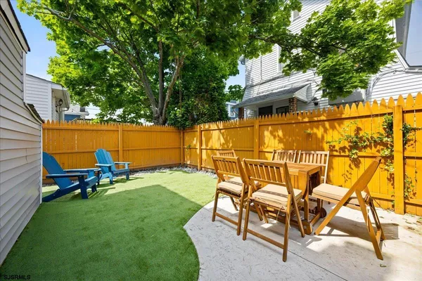 a backyard of a house with table and chairs