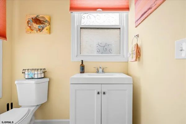 a bathroom with a sink mirror vanity and toilet