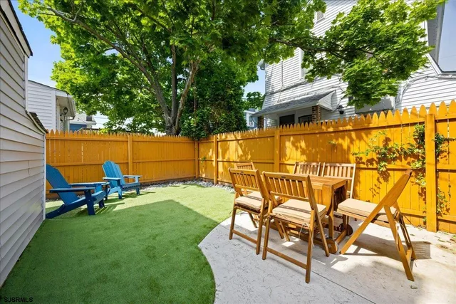 a backyard of a house with table and chairs