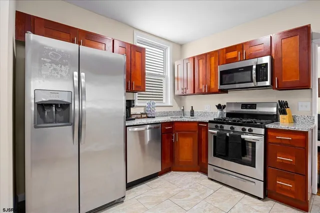 a kitchen with stainless steel appliances granite countertop a refrigerator stove and oven