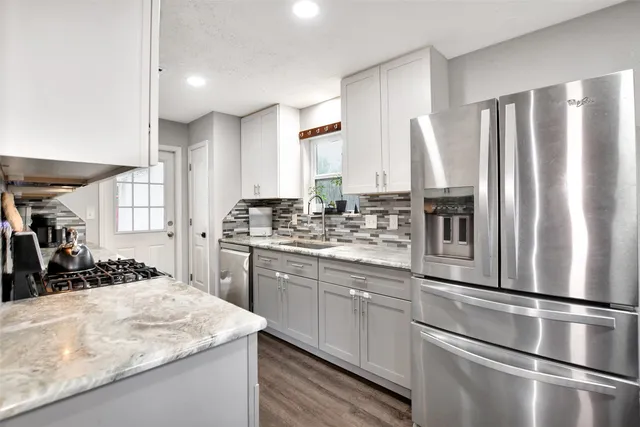 a kitchen with stainless steel appliances granite countertop a refrigerator sink and cabinets