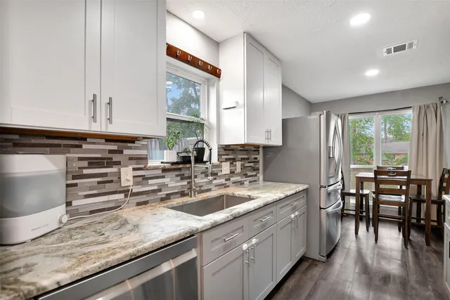 a kitchen with appliances a sink and cabinets