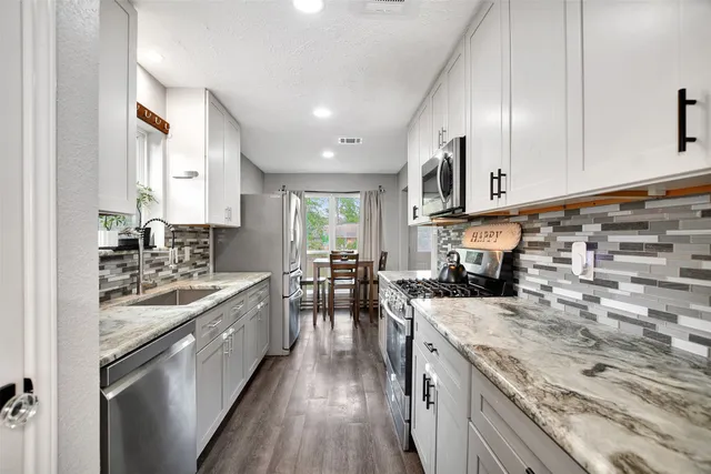 a kitchen with a stove sink and cabinets
