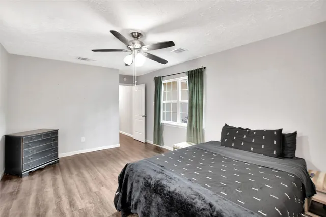 a bedroom with a large bed and a ceiling fan