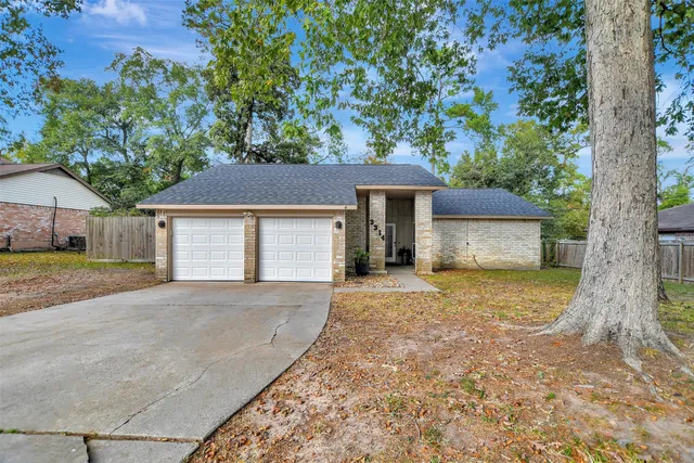 front view of a house with a yard and an trees