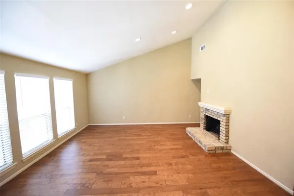 a view of an empty room with a fireplace and a window