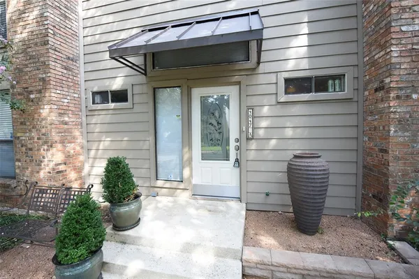 a front view of a house with potted plants