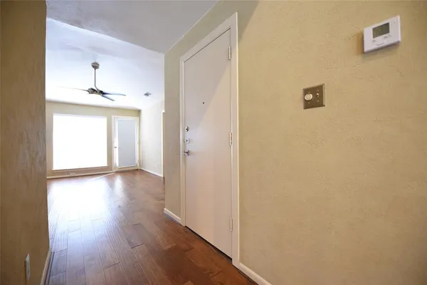 a view of a hallway with wooden floor