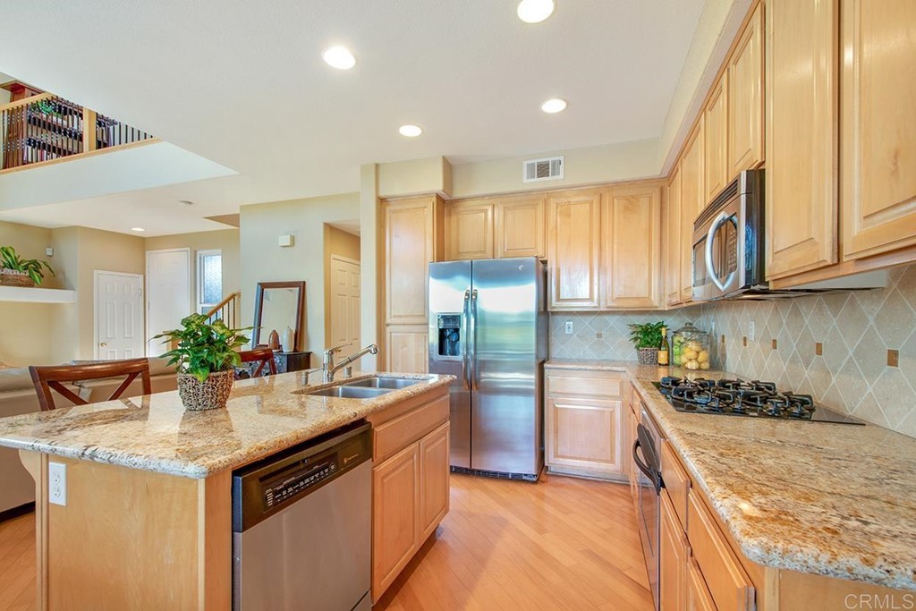 1723 Bluebird Lane Carlsbad, CA 92011 - Photo 11 of 33 a kitchen with stainless steel appliances granite countertop a sink stove and refrigerator