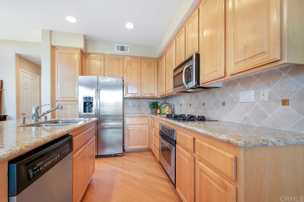 1723 Bluebird Lane Carlsbad, CA 92011 - Photo 12 of 33 a kitchen with stainless steel appliances granite countertop a sink stove and refrigerator