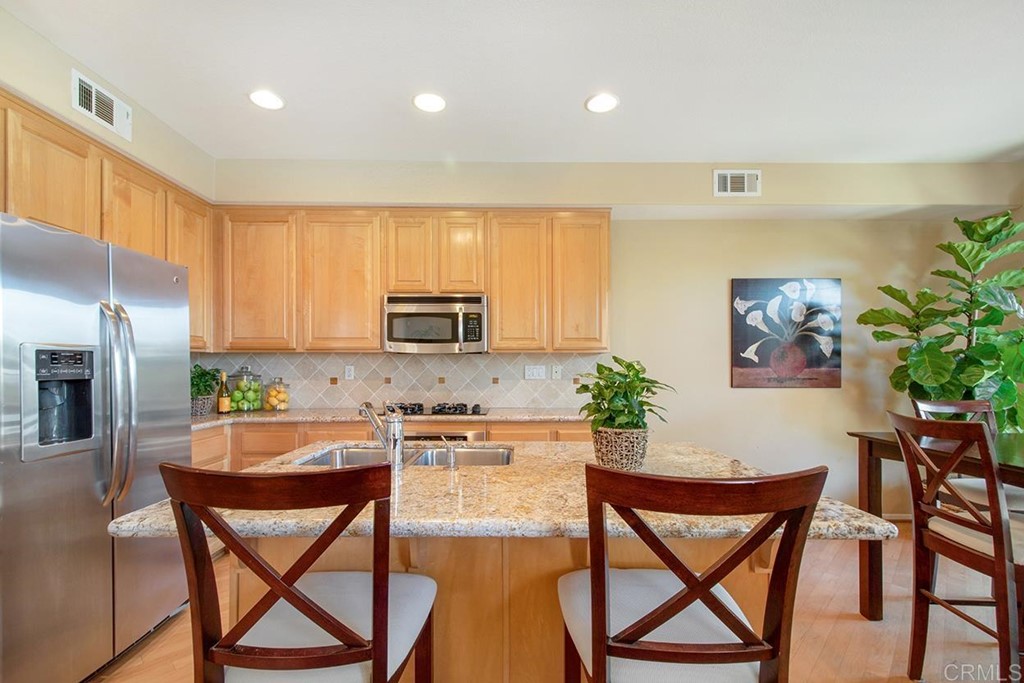 1723 Bluebird Lane Carlsbad, CA 92011 - Photo 9 of 33 a kitchen with a table chairs refrigerator and microwave