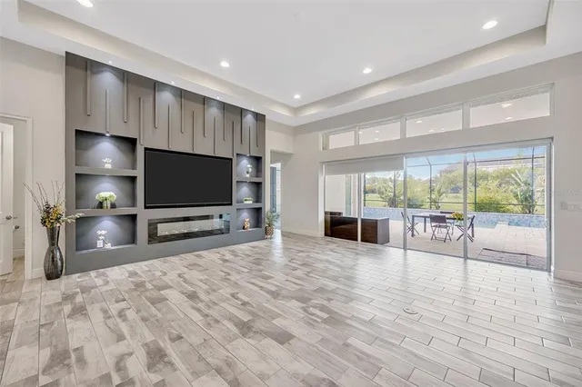 a view of an empty room with window and wooden floor