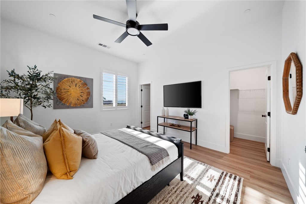 17042 Meteor Way Riverside, CA 92503 - Photo 32 of 75 a bedroom with a bed a flat screen tv and a chandelier