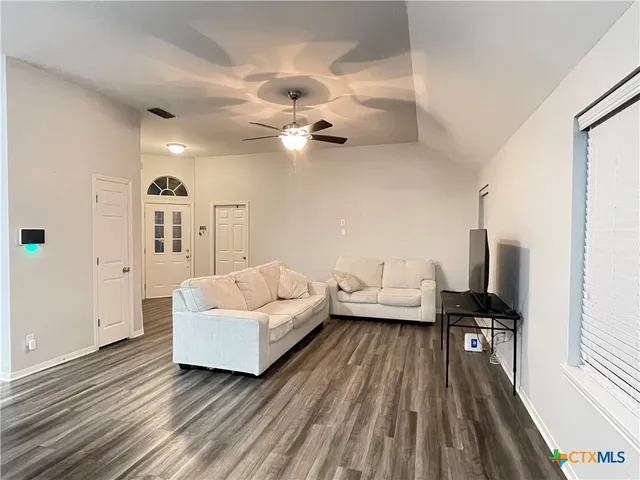 a living room with furniture and a wooden floor