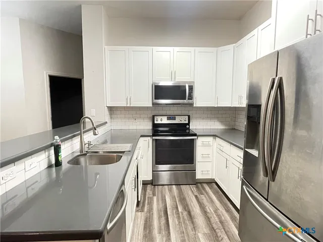 a kitchen with a refrigerator stove and sink