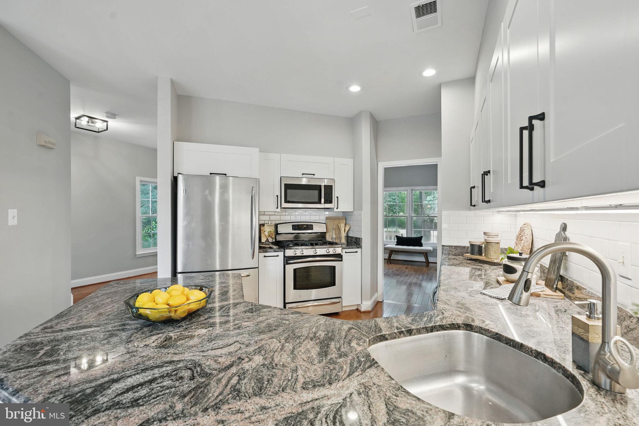 1393 Heritage Oak Way Reston, VA 20194 - Photo 18 of 80 a kitchen with stainless steel appliances granite countertop a sink and a refrigerator