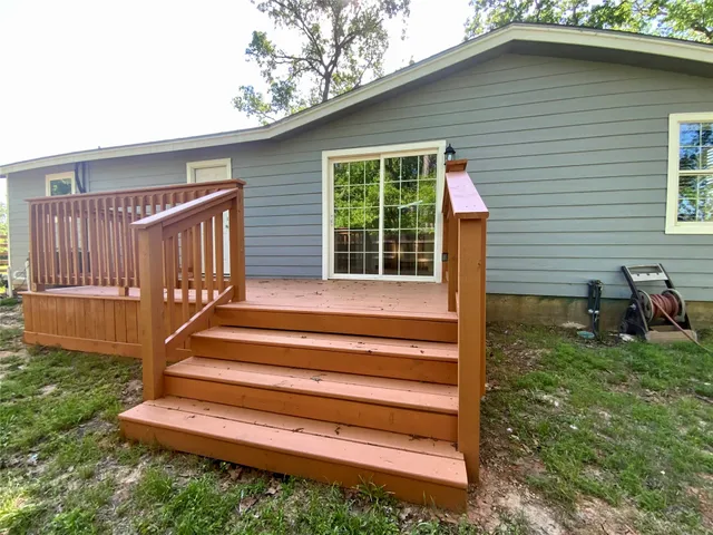 a view of backyard with deck and outdoor seating