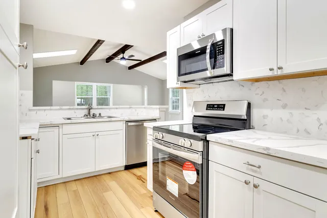 a kitchen with stainless steel appliances granite countertop a sink and a stove