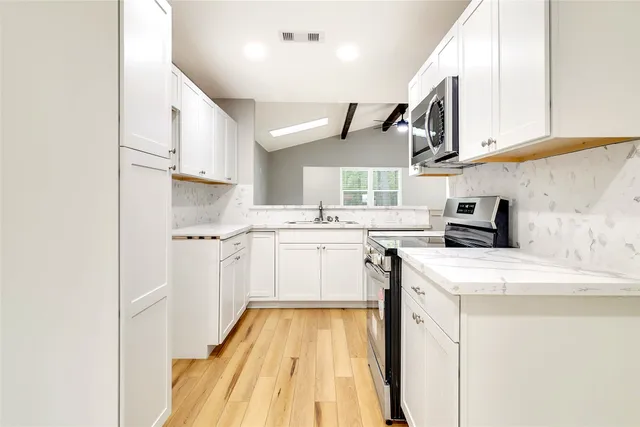 a kitchen with a sink a stove and cabinets