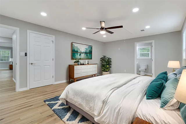 a spacious bedroom with a bed and a flat screen tv