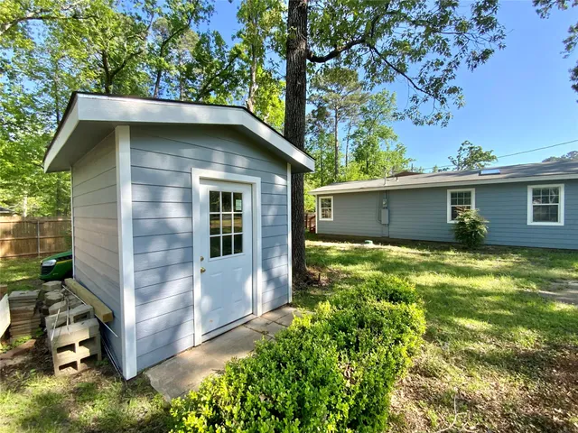 a front view of house with yard and trees in the background