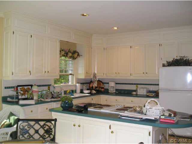 609 Rivers Bend Circle Chester, VA 23836 - Photo 5 of 8 a kitchen with granite countertop white cabinets and white appliances