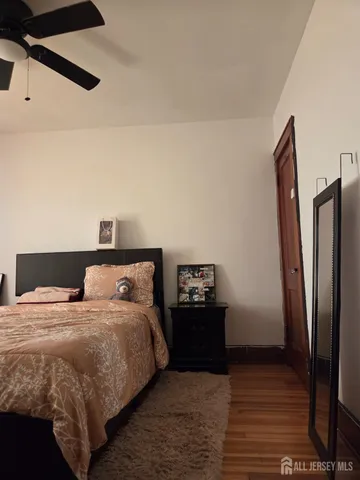 a bedroom with double bed and a refrigerator