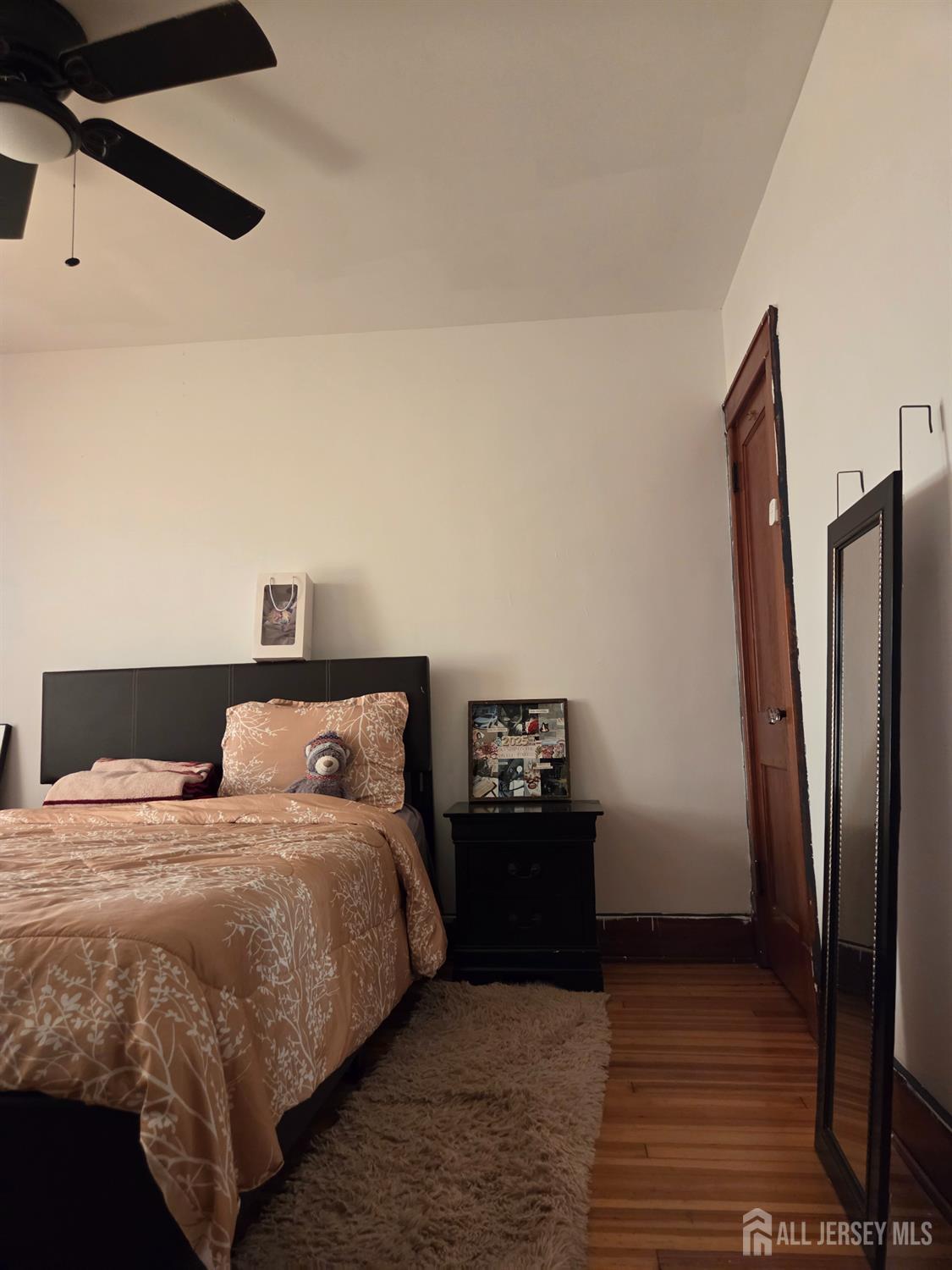 552 Compton Avenue Perth Amboy, NJ 08861 - Photo 4 of 13 a bedroom with double bed and a refrigerator