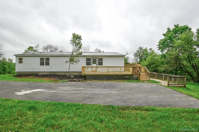 a front view of a house with a yard and trees